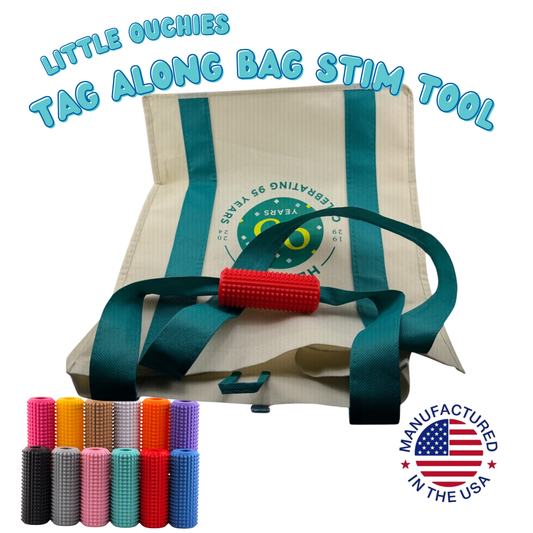 Red Little Ouchies Tag Along bag stim tool clipped onto the handle of a canvas tote bag, with the full thirteen-color lineup shown below