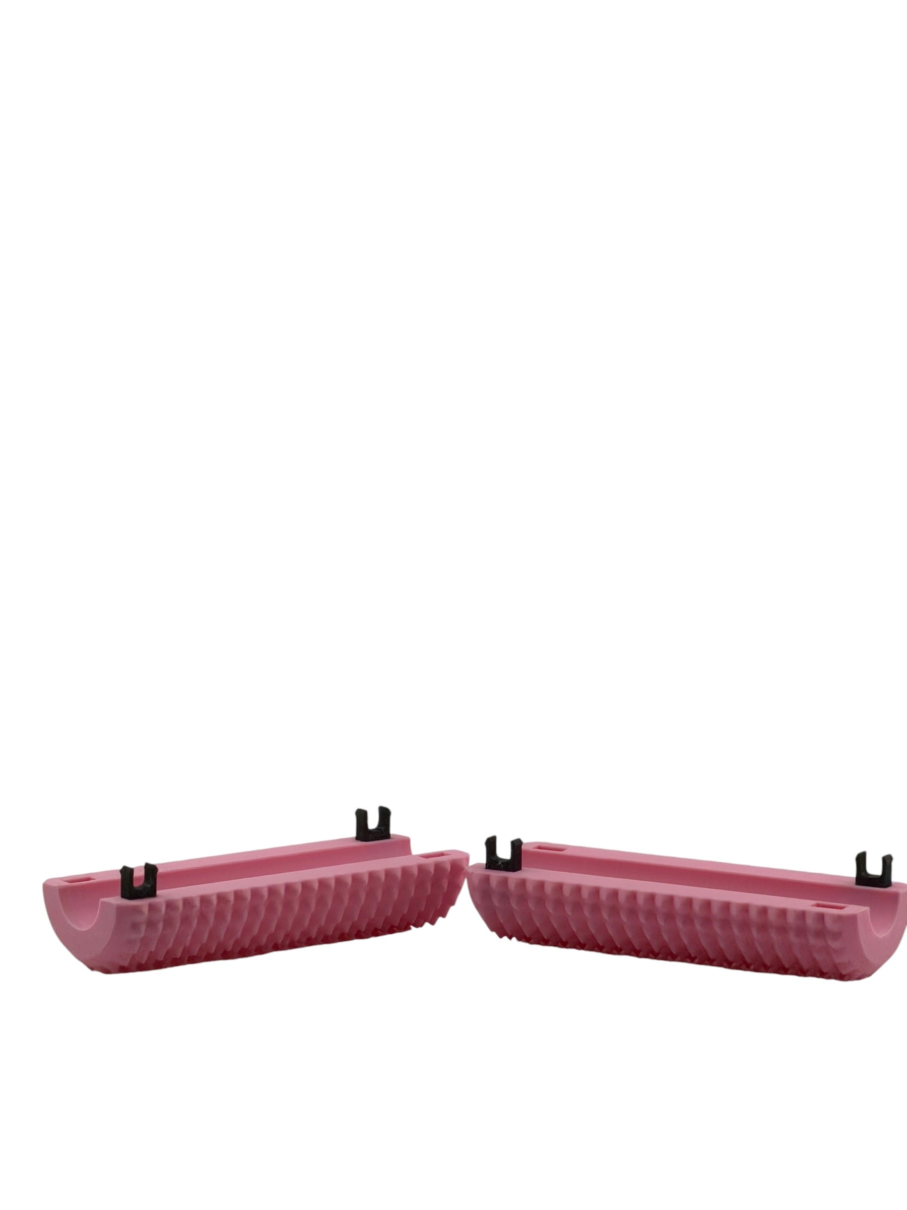 Two halves of a pink Little Ouchies Tag Along opened to show the black snap clips that close around a bag strap