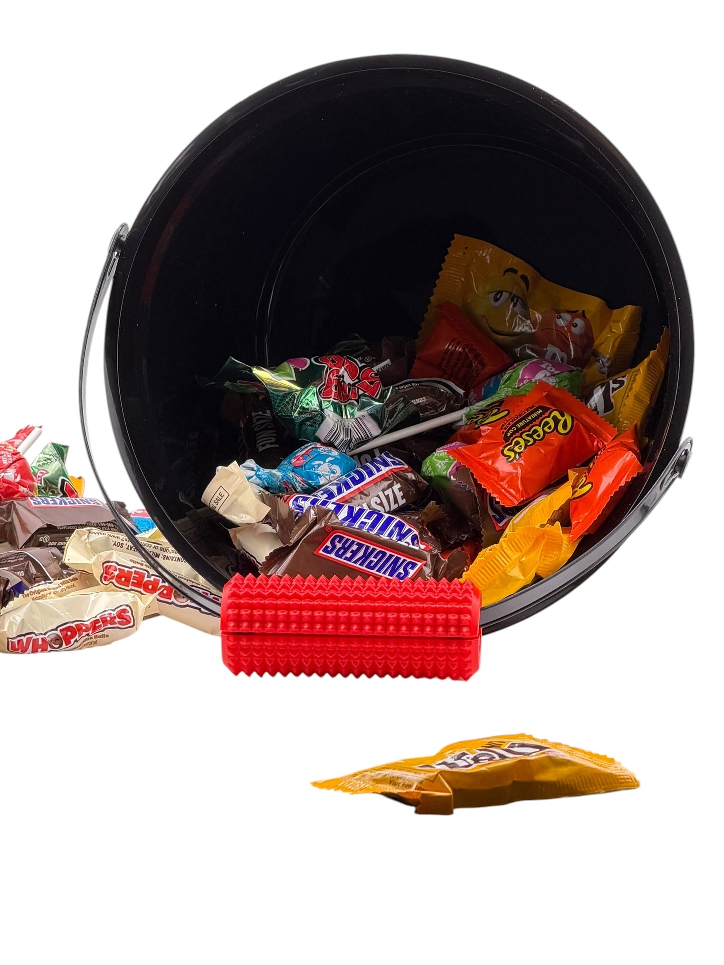 Red Little Ouchies Tag Along fidget clipped onto the handle of a Halloween trick-or-treat candy pail