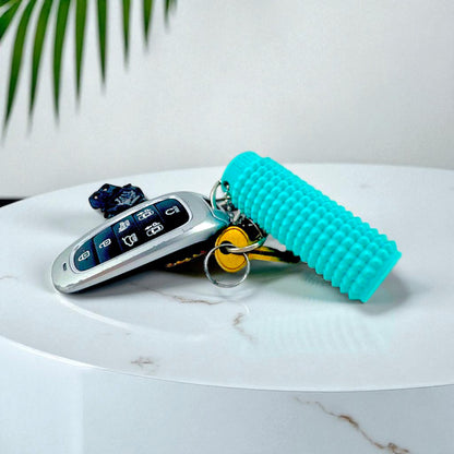 Little Ouchies Grippies shown on a keychain on a table, Little Ouchies Grippies are designed for pain stims, Little Ouchies Grippies for anxiety and stress, Little Ouchies for sensory regulation, Little Ouchies for self-soothing, pain stim toys for kids, autism fidgets for adults, discrete fidget toys 