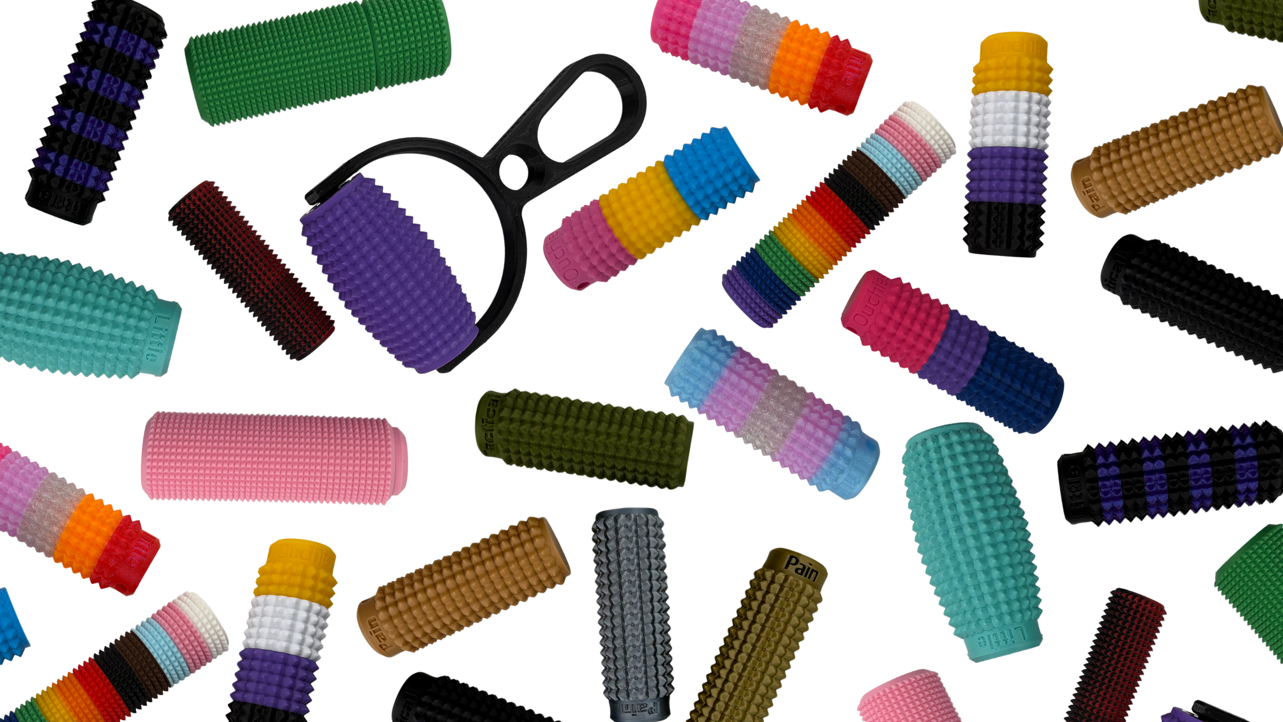 A bunch of Little Ouchies products spread out. Little Ouchies Grippies, Little Ouchies Spkies, Little Ouchies Pride Collection, Little Ouchies Grippie Roller, Little Ouchies Tactical Pain Collection, Little Ouchies Click, Little Ouchies Spin-Click, Little Ouchies Ergo, Little Ouchies Minis